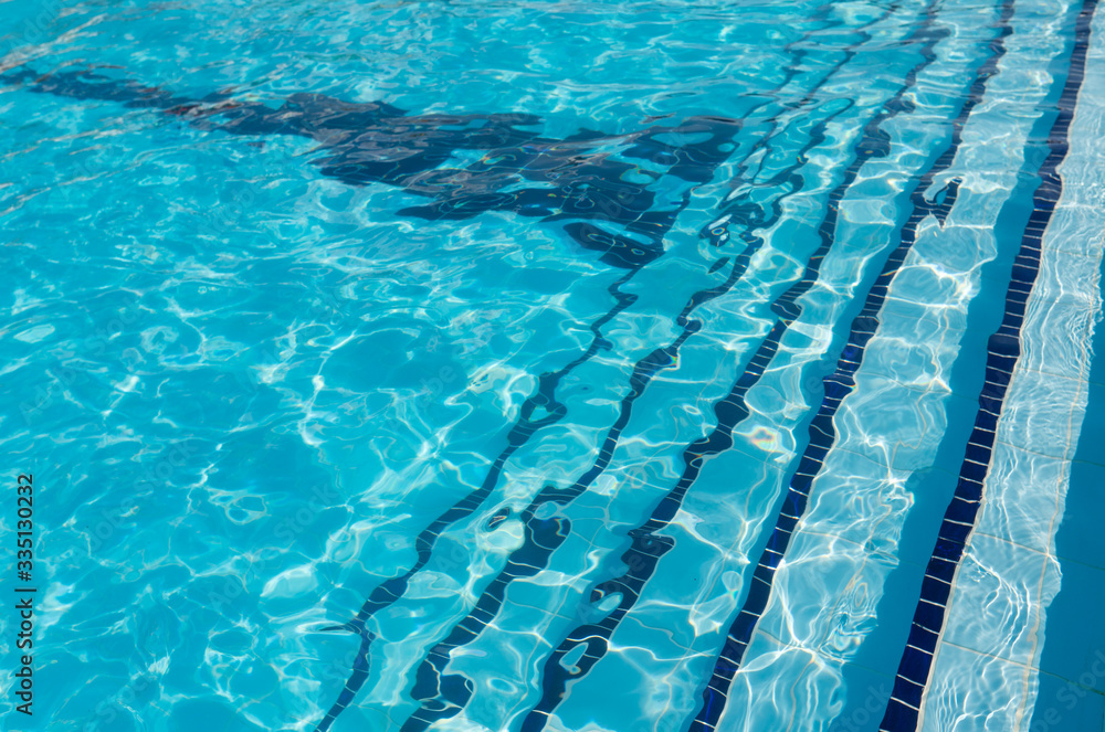 The texture of the crystal clear water in the pool. Safe swimming. Water in bright light