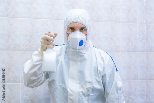 Doctor in protective suit with antiseptic spray in hands at pandemic period. Epidemic disease concept.  photo