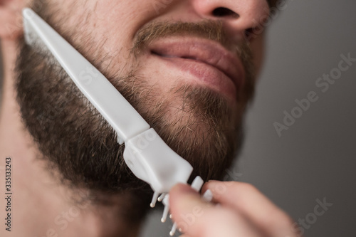 Foto A man combing his beard with a comb