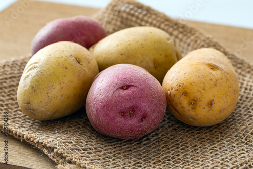 Close up of bite size yellow and red potatoes on gunny sack