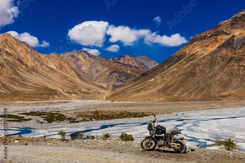 spiti valley motorbike trip in india with mountains in background and a motorcycle in the foreground