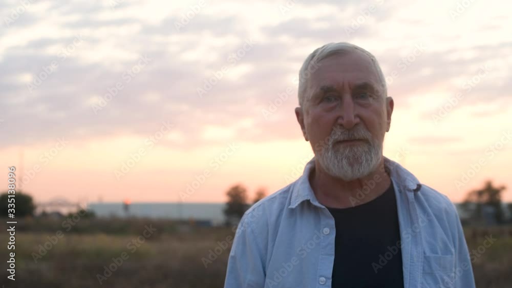Elderly man with a gray beard at sunset in field, concept of emotions Elderly man with a gray beard at sunset in field, concept of emotions