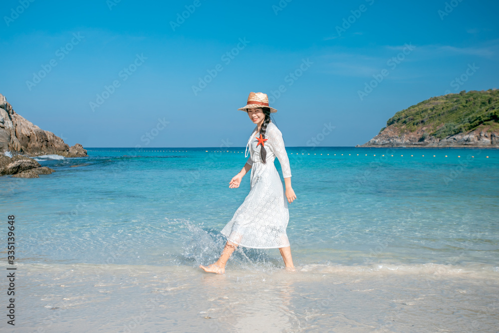 A healthy woman in a white dress walks on the beach. A healthy woman in a white dress walks on the beach.