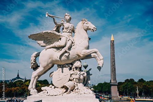 Angel on horse statue with Luxor Egyptian obelisk in the background at the Place de la Concorde in Paris, France