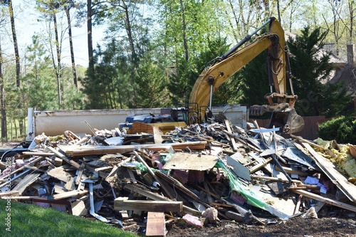 A backhoe picking up trash