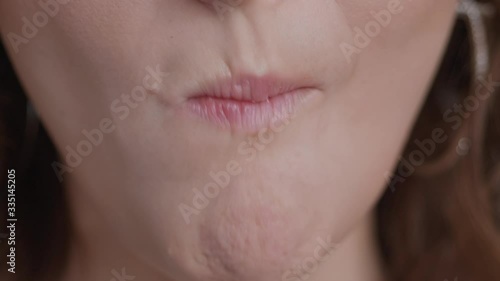 Detail shot of caucasian woman mouth eating chews banana liten natural window light