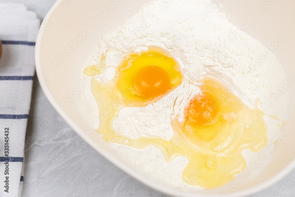 Top view of smashed eggs in flour ready for creating dough Top view of smashed eggs in flour ready for creating dough
