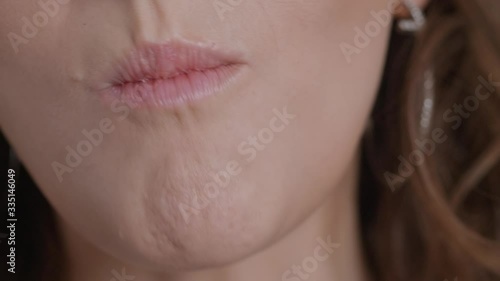 Detail shot of caucasian woman mouth eating chews banana liten natural window light
