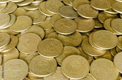 Pile of 5 and 10 peso coins in a flat view 