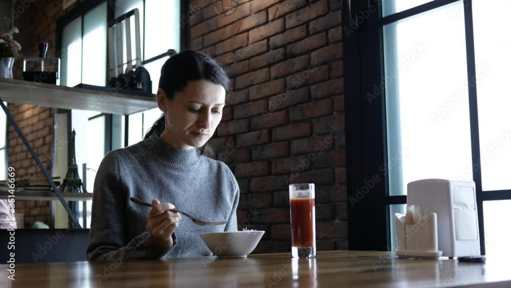 Beautiful young happy woman sitting at the table in cafe and enjoying the meal. Attractive hungry woman eating tasty lunch Beautiful young happy woman sitting at the table in cafe and enjoying the meal. Attractive hungry woman eating tasty lunch