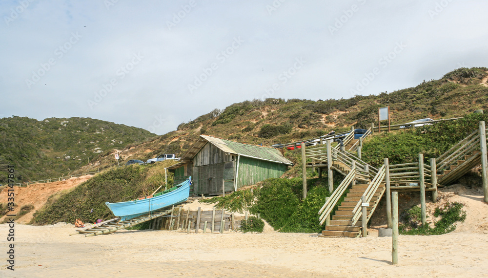 A wooden house on the beach with its own boat A wooden house on the beach with its own boat