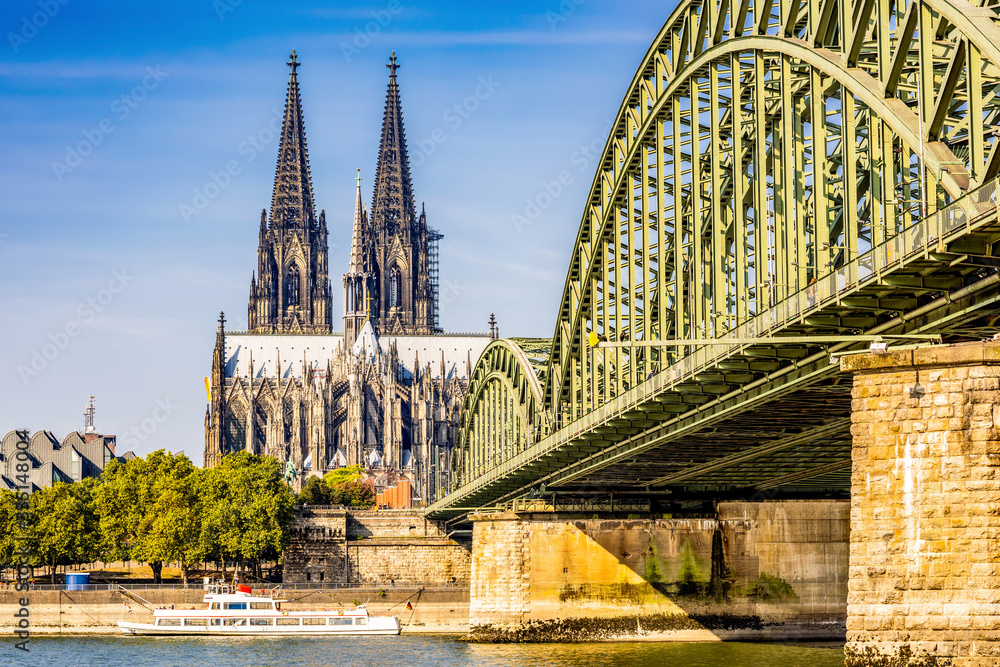 Fototapeta premium Cologne with the Cologne Cathedral and the Hohenzollern Bridge in the light of the morning sun