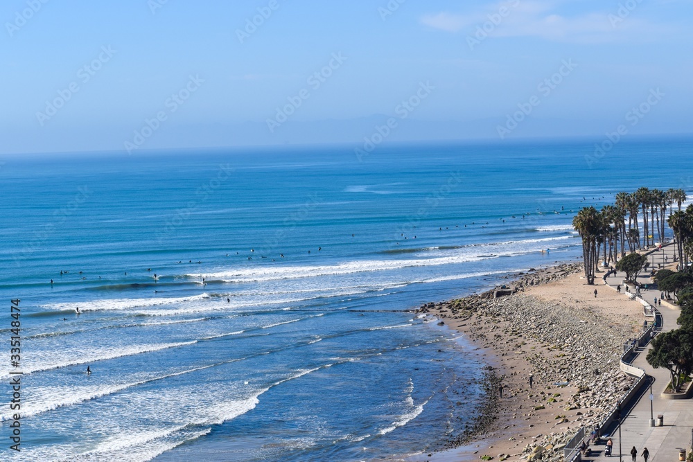 Surfer and beach goers flock blue ocean beach Surfer and beach goers flock blue ocean beach
