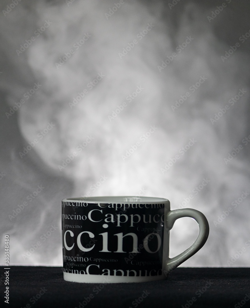 cup of cappuccino with smoke in the background with a white light with air of suspense. cup of cappuccino with smoke in the background with a white light with air of suspense.
