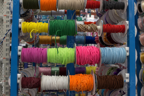 Εκτύπωση καμβά multi-colored braids and elastic bands wound on bobbins on the counter of the st