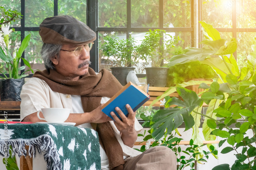 Healthy Asian senior man enjoy retirement in his greenhouse garden with reading a book. Handsome old man relaxing at home during quarantine. Elderly person lifestyle activity and healthcare concept. Healthy Asian senior man enjoy retirement in his greenhouse garden with reading a book. Handsome old man relaxing at home during quarantine. Elderly person lifestyle activity and healthcare concept.