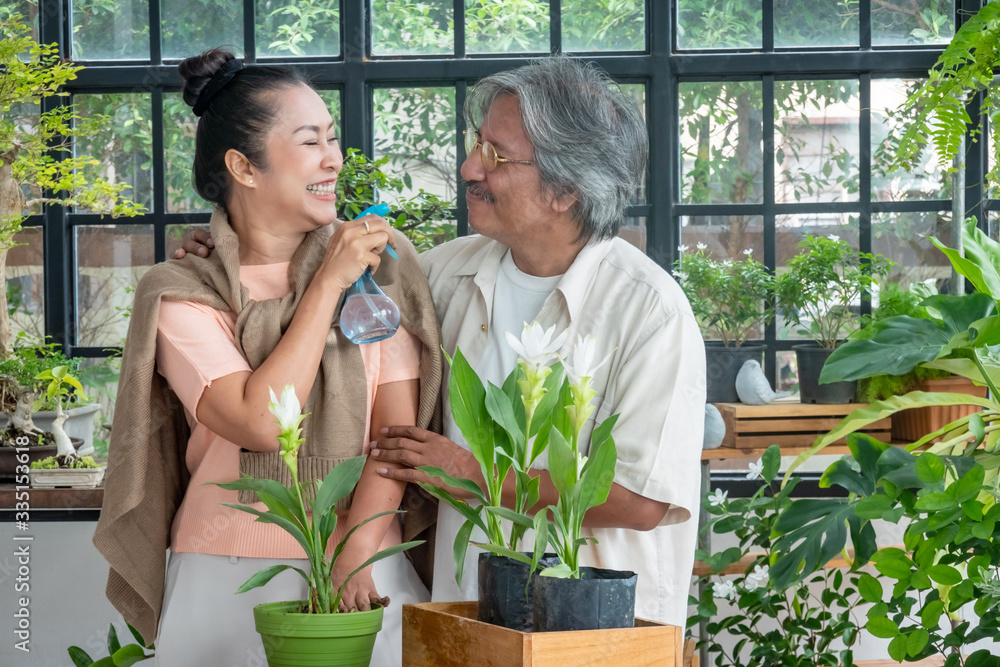 Obraz premium Healthy Asian senior couple man and woman relaxing together in greenhouse garden. Retirement old age family enjoy romantic moment at home. Elderly person with leisure lifestyle and healthcare concept.