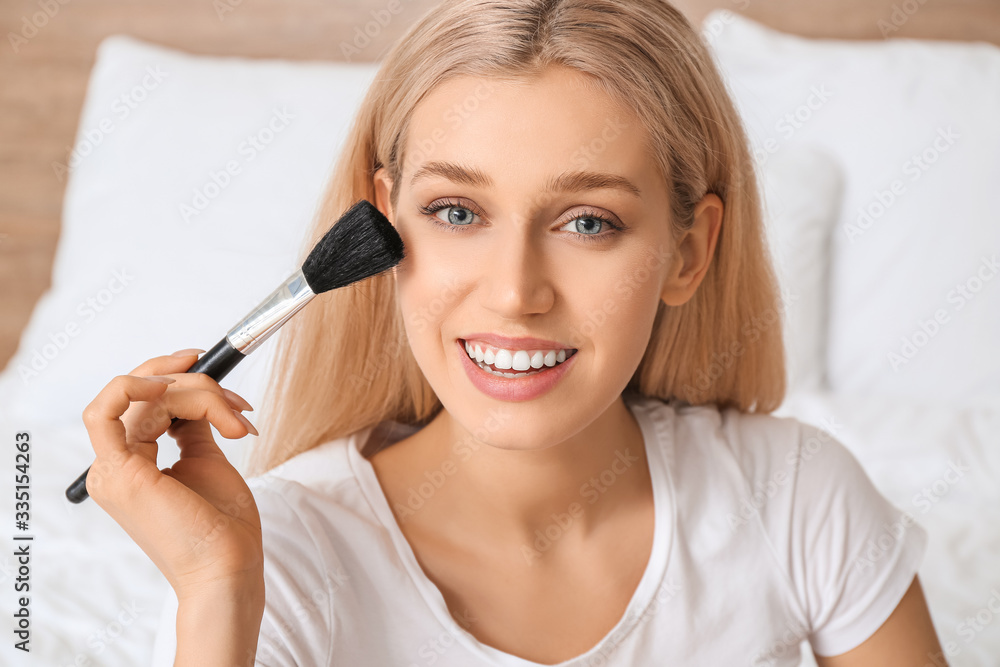 Beautiful young woman applying makeup at home Beautiful young woman applying makeup at home
