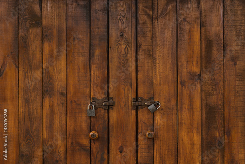 Powerful wooden doors with padlocks. Dark Wood texture.