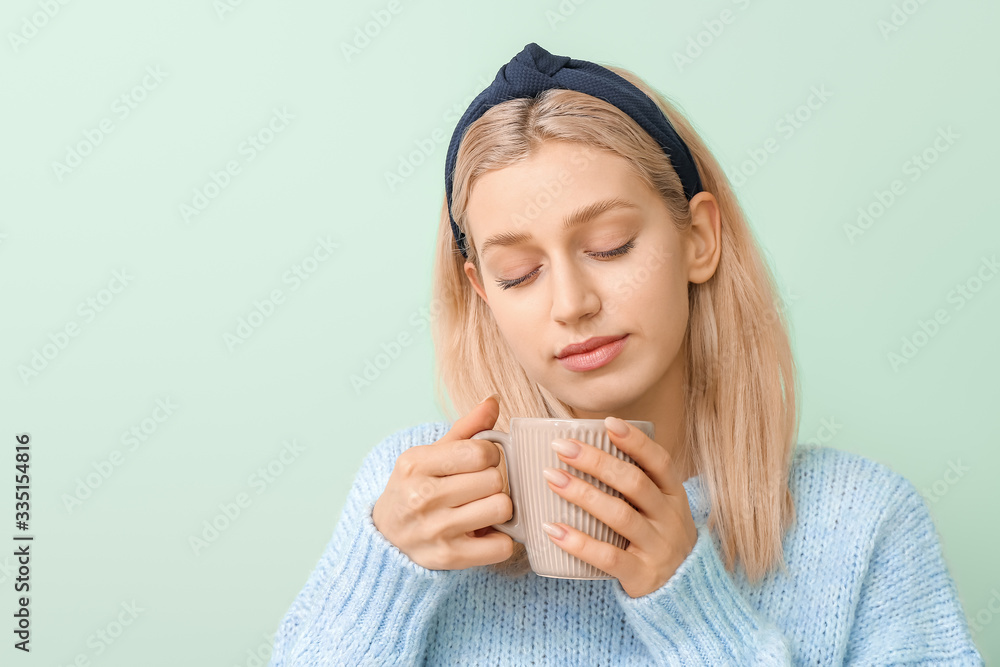 Beautiful young woman with tea on color background Beautiful young woman with tea on color background