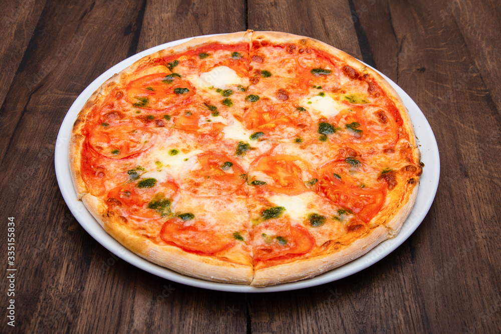 Classic Italian pizza on a wooden table Classic Italian pizza on a wooden table