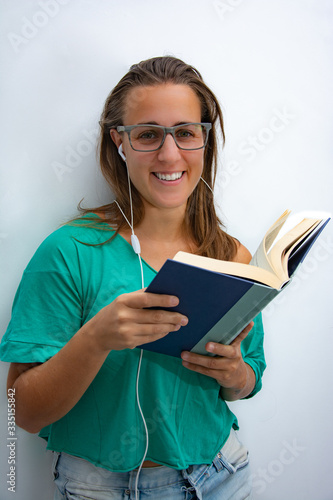 Woman reading a book and listening music in quarantine