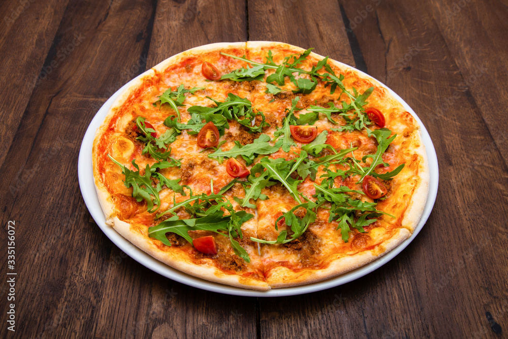 Classic Italian pizza on a wooden table Classic Italian pizza on a wooden table