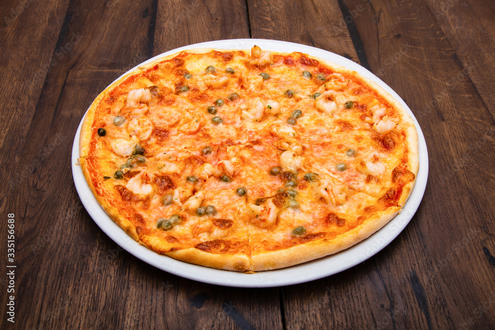Classic Italian pizza on a wooden table Classic Italian pizza on a wooden table