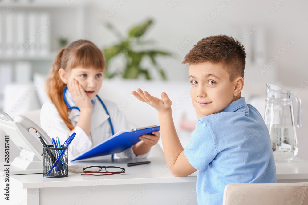 Cute little doctor working with patient in clinic