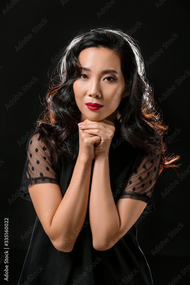 Young Asian woman with beautiful hair on dark background Young Asian woman with beautiful hair on dark background