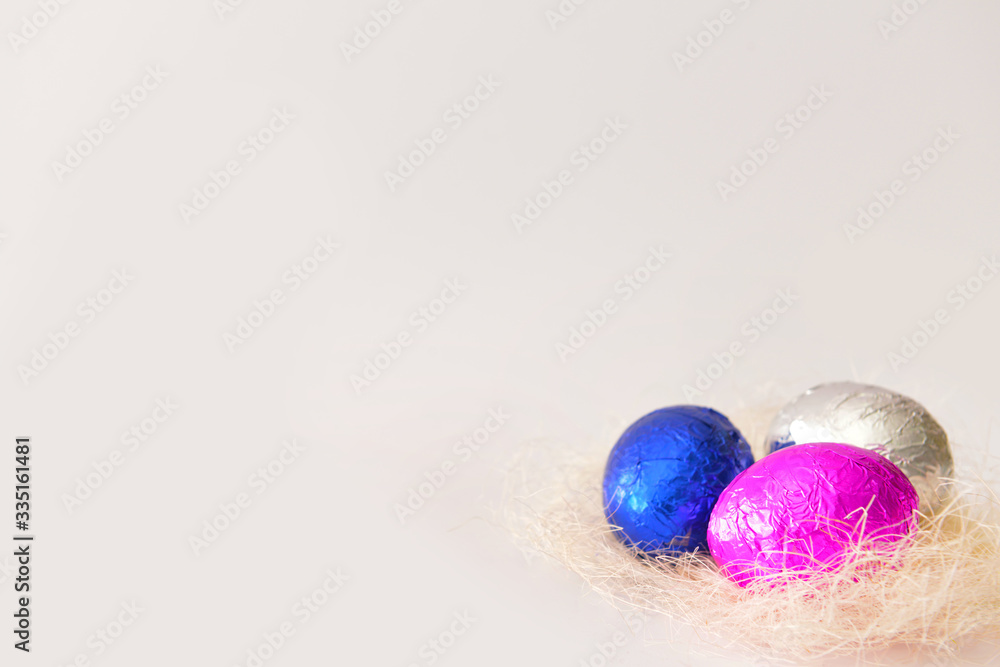 Nest with sweet chocolate eggs on white background Nest with sweet chocolate eggs on white background