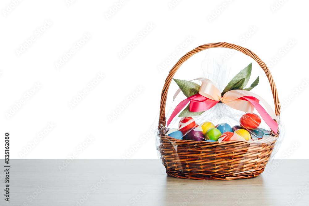 Easter gift basket with multicolor eggs, white background