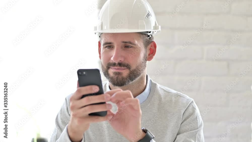 Portrait of Cheerful Young Engineer using Smartphone Portrait of Cheerful Young Engineer using Smartphone