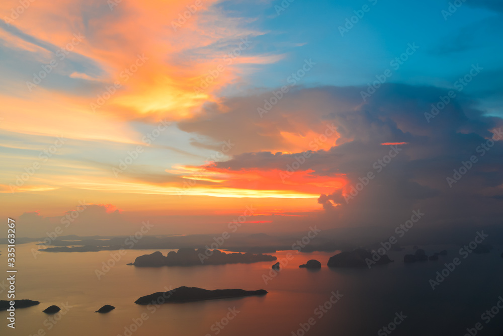 Top view of Beautiful sunset sky and multicolor clouds from airplane before landing at Phuket international airport