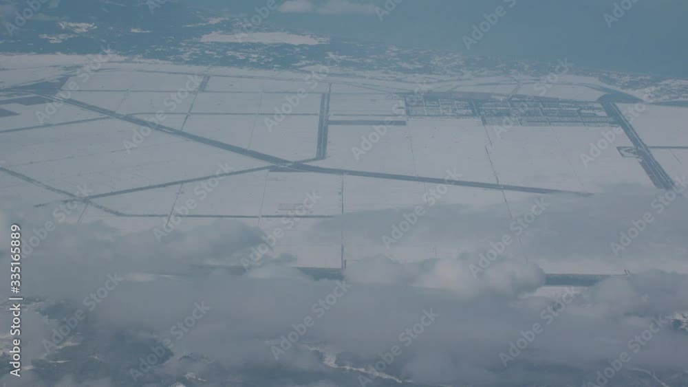 JAPAN : Aerial view of North East area of Japan in December winter season. View of snow covered land. Houses, street and road covered with heavy snow. Winter travel and journey concept shot. JAPAN : Aerial view of North East area of Japan in December winter season. View of snow covered land. Houses, street and road covered with heavy snow. Winter travel and journey concept shot.