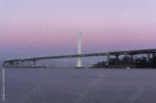 Bay Bridge from Treasure Island with natural purple haze sunset. Port of Oakland in the background.