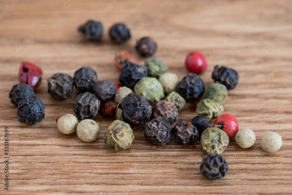 Variety of peppercorns on a wooden service. Variety of peppercorns on a wooden service.