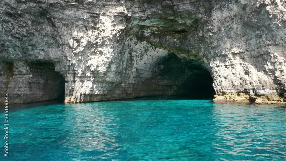 Tracking shot entering a cave inside a blue turquoise sea water Tracking shot entering a cave inside a blue turquoise sea water