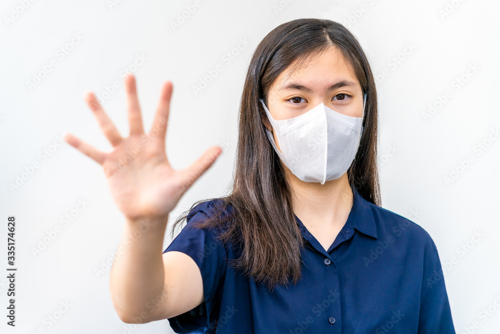 Young Asian female teenager wearing N95 mask and put up her hand to stop the COVID-19 virus Young Asian female teenager wearing N95 mask and put up her hand to stop the COVID-19 virus