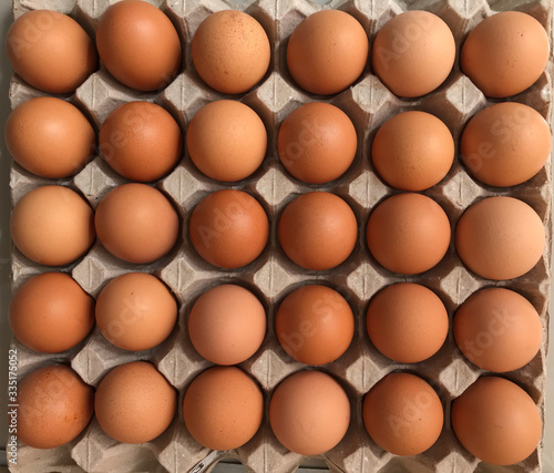 thirty fresh organic chicken eggs in grey paper egg tray from top view