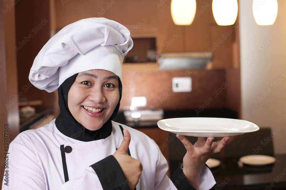 Asian Female Chef Shows Empty White Plate, Presenting Something, Copy Space Asian Female Chef Shows Empty White Plate, Presenting Something, Copy Space