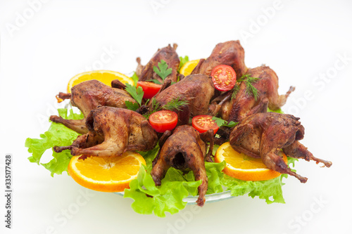 Fried quail in the orange with tomato and fresh parsley and spices