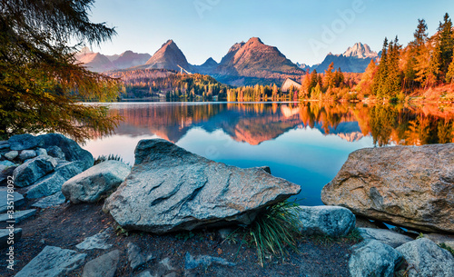 Last sunlight glowing of mountain hills on Strbske pleso lake. Exciting evening scene of High Tatras National Park, Slovakia, Europe. Beauty of nature concept background.