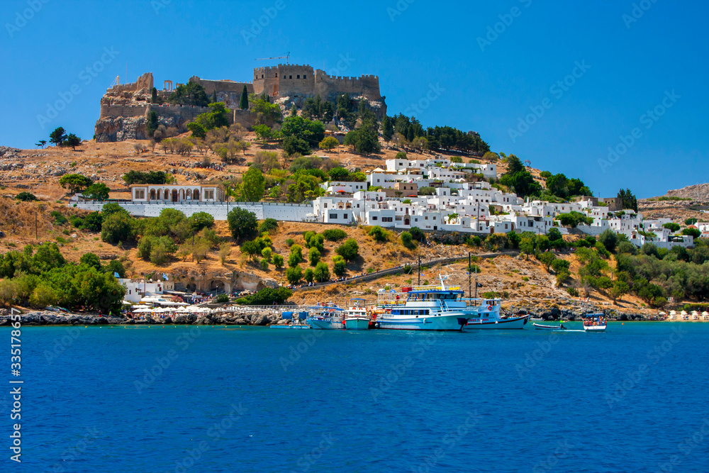 The ancient walled city stands on a high cliff on the shore of the blue sea