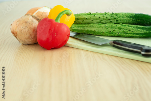 테이블 위 야채, 오이, 파프리카, 양파도마, 칼 photo