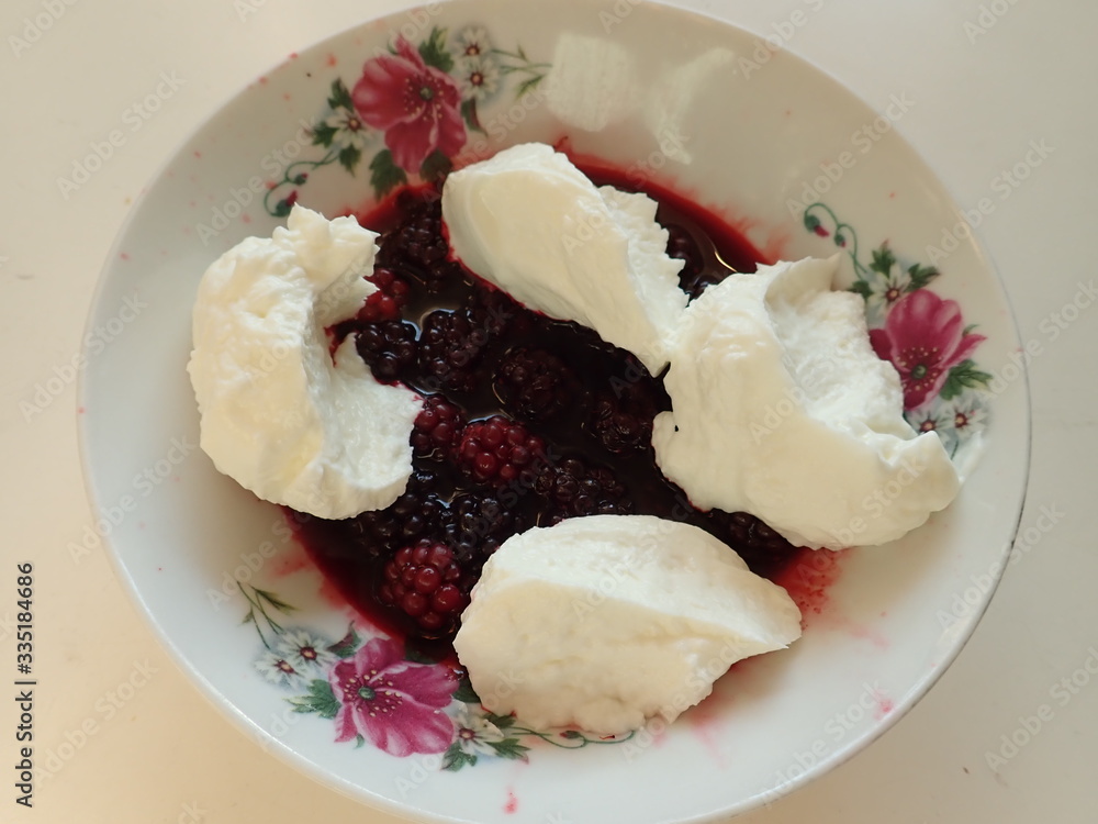 blackberries with cream in white decorated bowl blackberries with cream in white decorated bowl