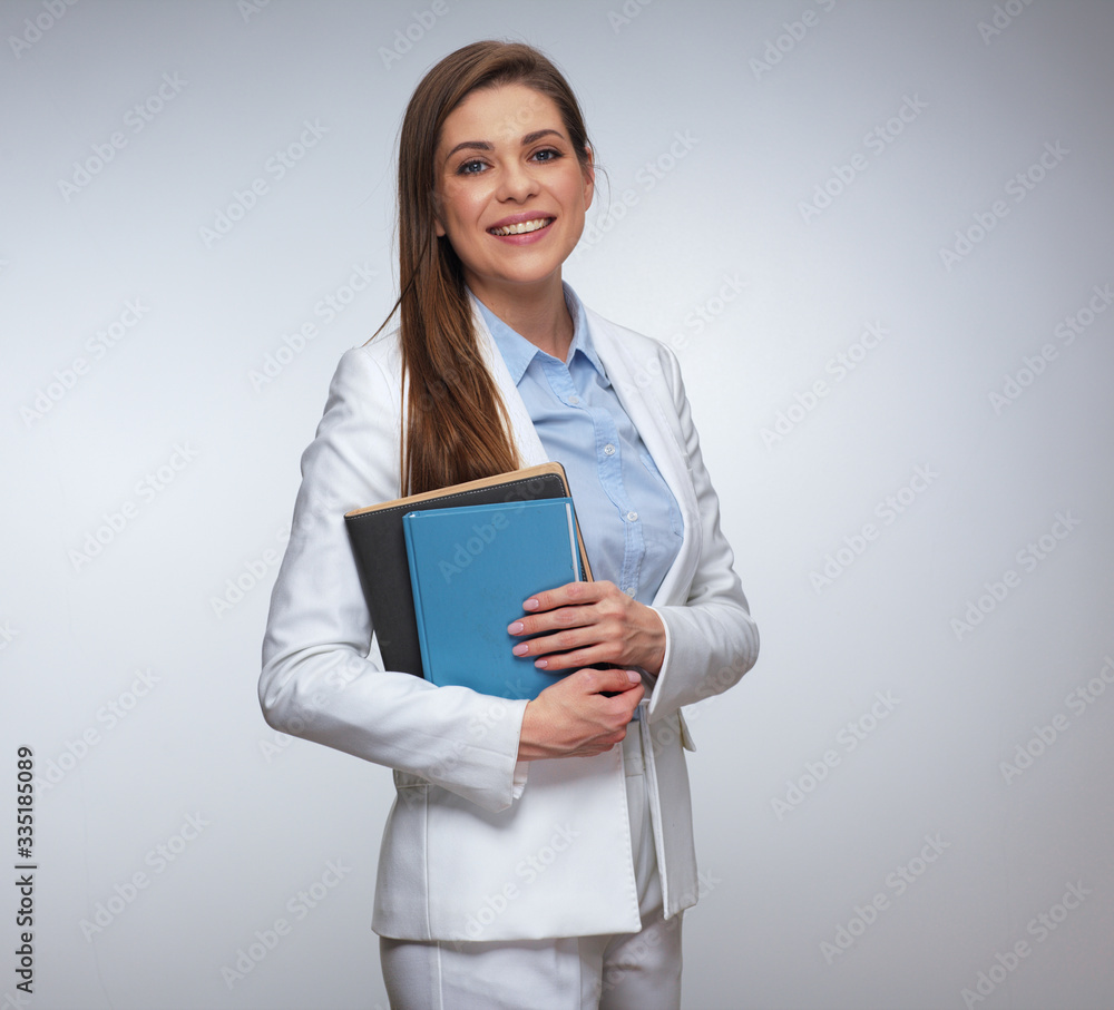 Smiling woman in white business suit holding books. Smiling woman in white business suit holding books.
