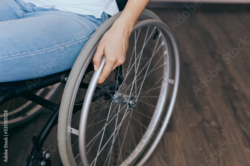 Unrecognizable disabled woman in wheelchair at home. Recovery and healthcare concepts.