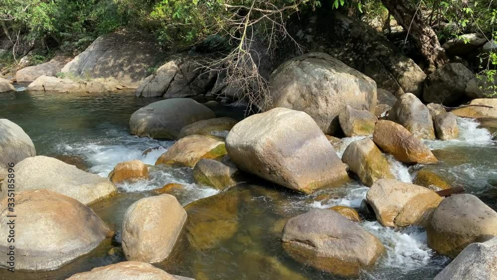 mountain stream flows through large stones, foam from the flow of water.jungle mountain stream flows through large stones, foam from the flow of water.jungle