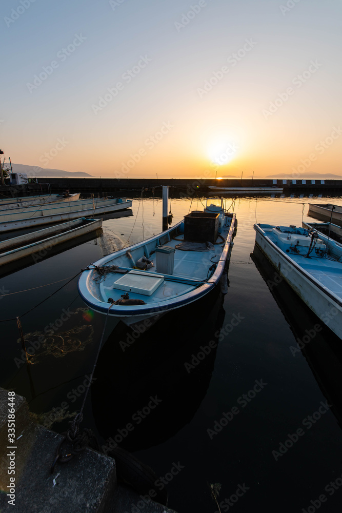 琵琶湖の漁港の漁船と昇る太陽